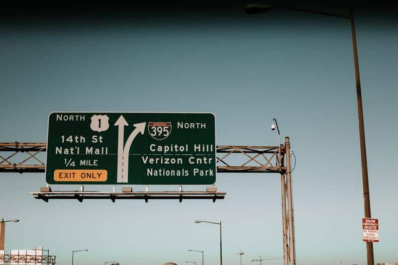 An interstate/highway sign against a light blue sky