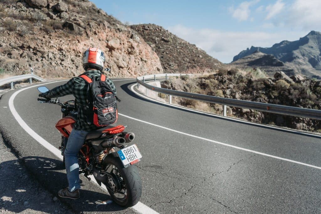 A motorcyclist pulled over on the side of a mountain highway
https://unsplash.com/photos/g9d1T1nzmEA?utm_source=unsplash&utm_medium=referral&utm_content=creditShareLink