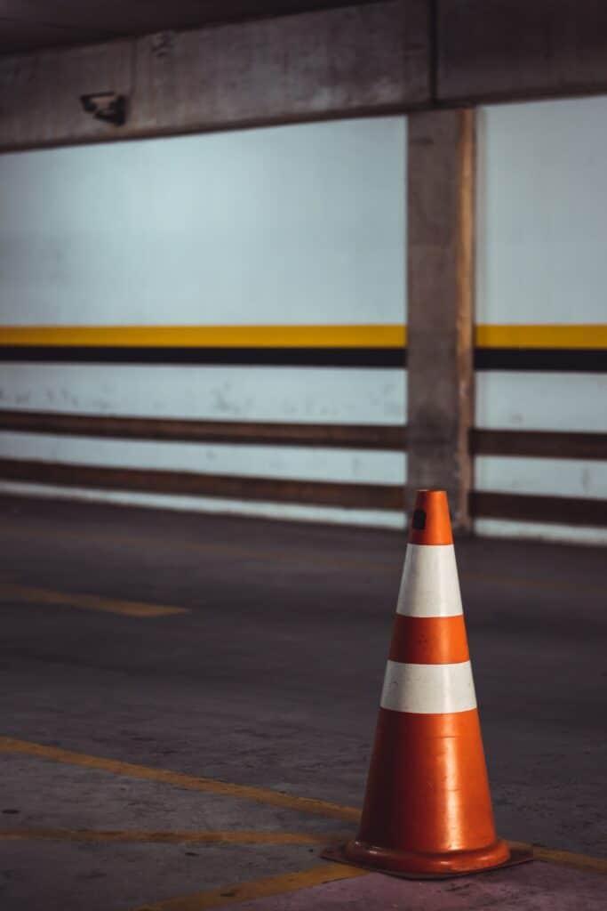 An orange cone with two reflective collars in a parking garage being used as a piece of traffic safety equipment
https://unsplash.com/photos/qxy9rs366GE?utm_source=unsplash&utm_medium=referral&utm_content=creditShareLink 