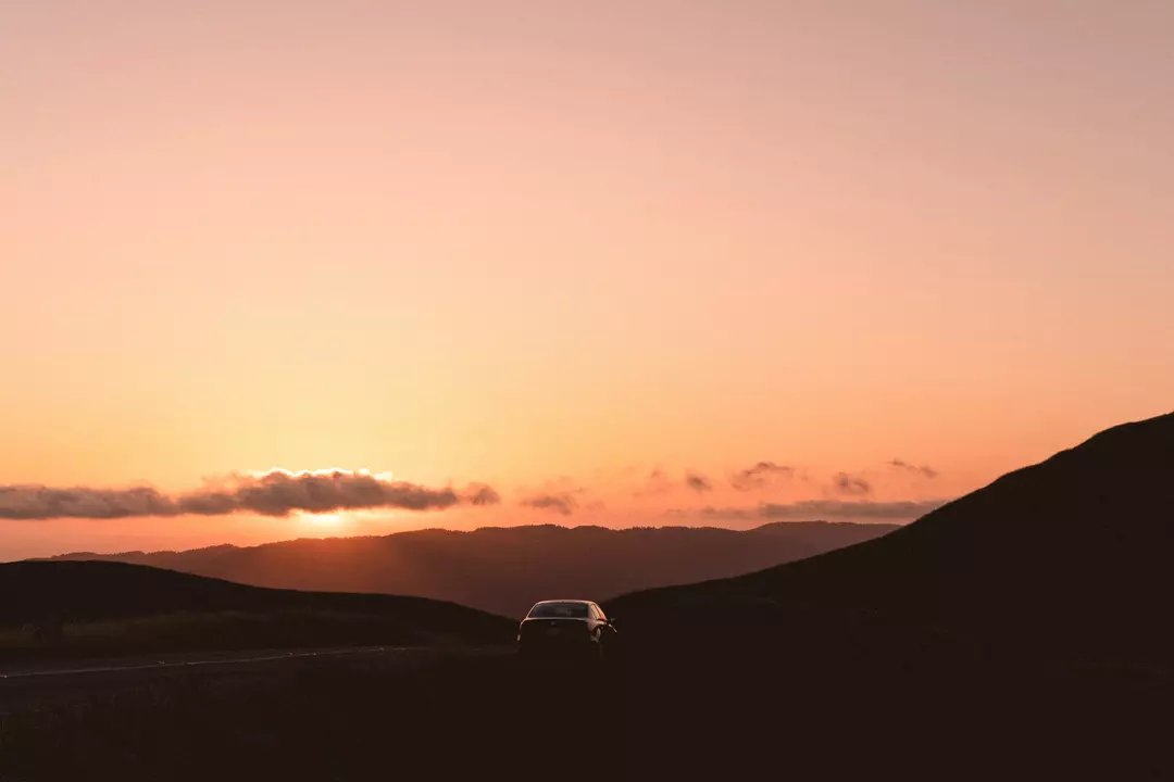 A car driving into the sunset