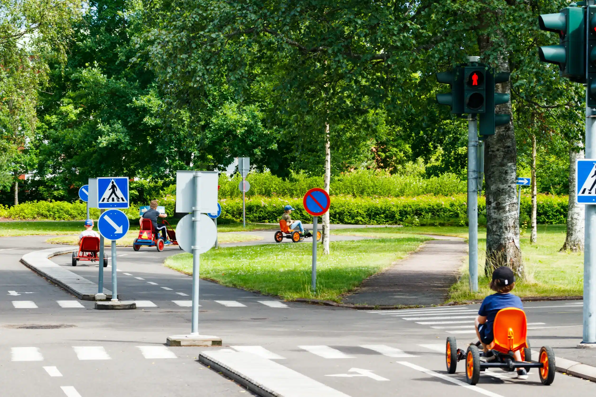Kids riding bikes in an area with pedestrian and bicycle road signs