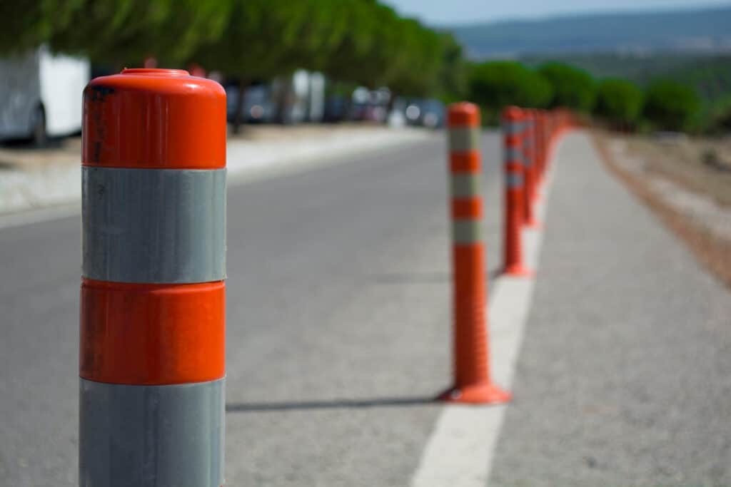 A long row of traffic warning cones on a road
