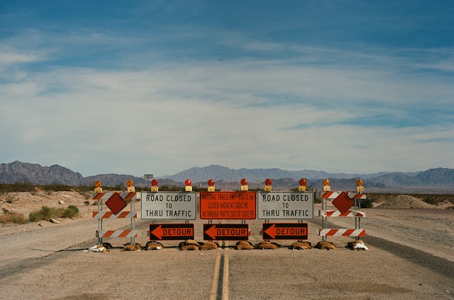 A row of different types of construction signs on a road under construction