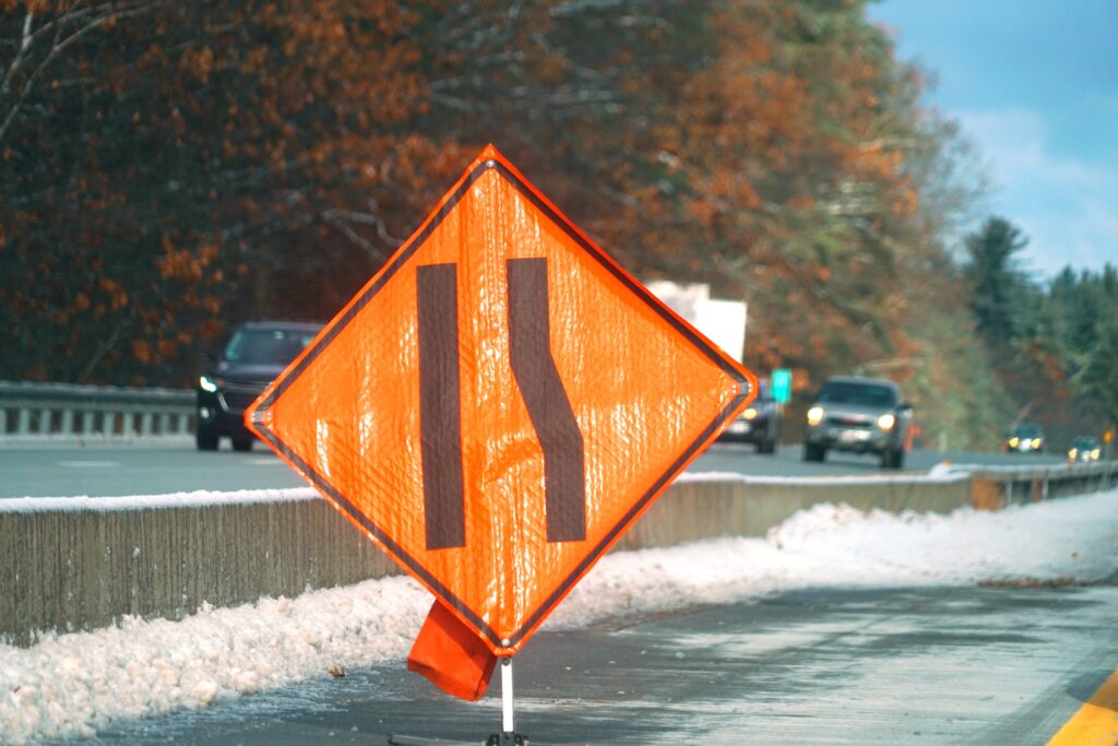 A reflective merge sign in a construction zone providing road safety in winter