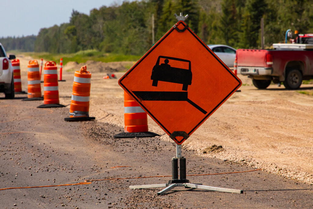 Orange cones and a road sign to help with work zone crash prevention